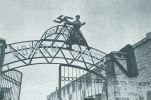 Советский солдат срывает нацистскую свастику с ворот металлургического завода им. Войков